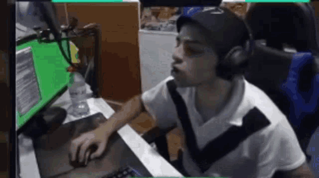 a man wearing headphones is sitting in front of a computer monitor