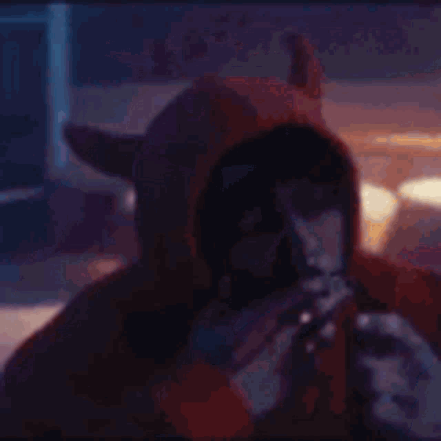 a person wearing a devil costume is lighting a candle .