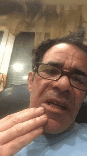 a man wearing glasses holds a piece of food in his hand