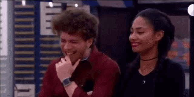 a man and a woman are sitting next to each other and the man is laughing while the woman is smiling .