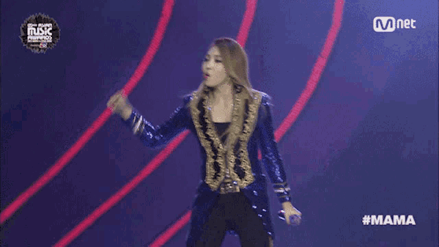a woman in a blue sequined jacket holds a microphone in front of a mnet advertisement