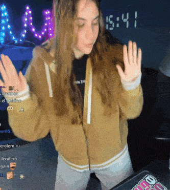 a woman dancing in front of a clock that says 15:44