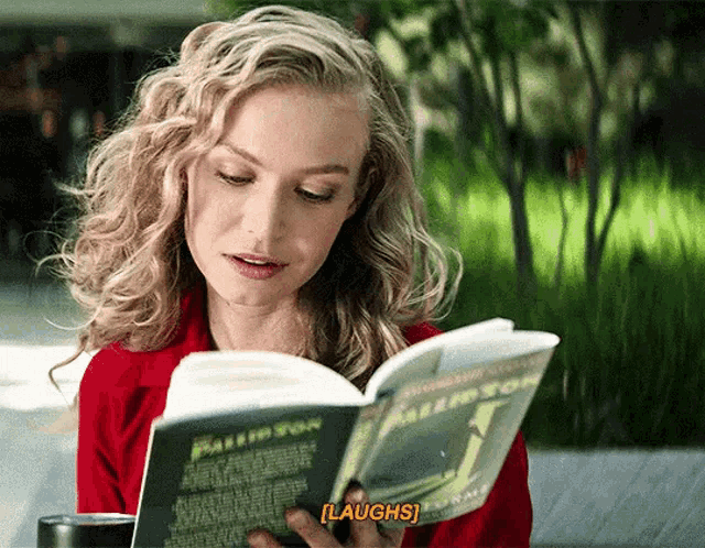 a woman laughs while reading a book by paulo fon