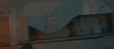 a man is standing in front of a large explosion in a dark room .