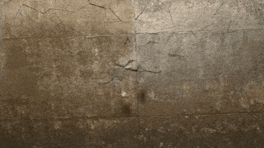 a close up of a cracked wall with a light shining through it