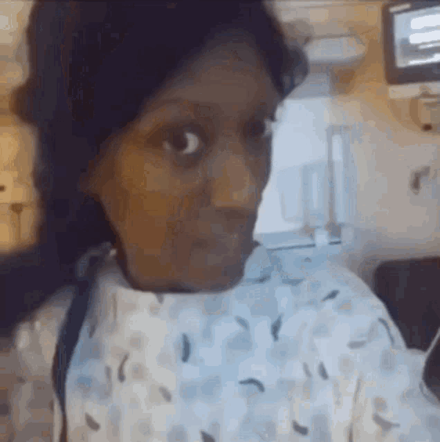 a woman in a hospital gown is looking at something