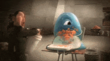 a man is standing next to a blue monster that is eating a plate of food
