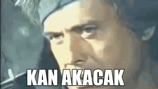 a close up of a man 's face with the words kan akacak written on it .