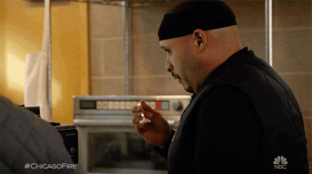 a man is standing in front of a microwave with the hashtag #chicagofire on the bottom