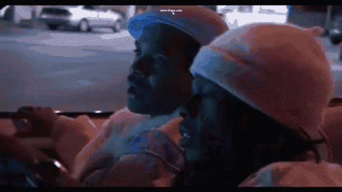 a man and woman are sitting in the back seat of a car .