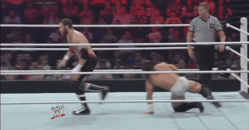 two men are wrestling in a wrestling ring with a referee watching and the words #smackdown on the bottom