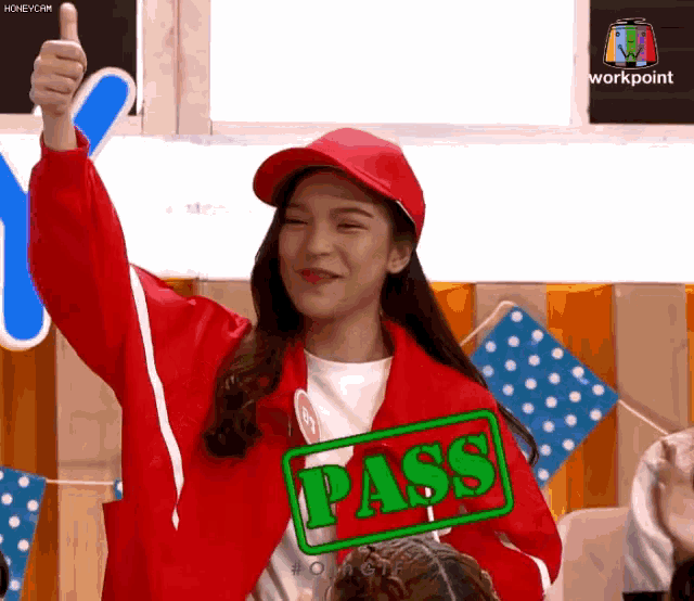 a woman giving a thumbs up with a pass stamp