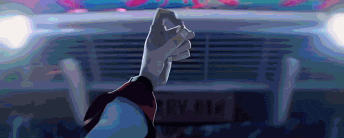 a person 's fist is raised in the air in front of a car with a license plate that says rv 412