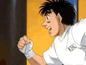 a man in a white shirt with the word kbg on it is punching a bag .