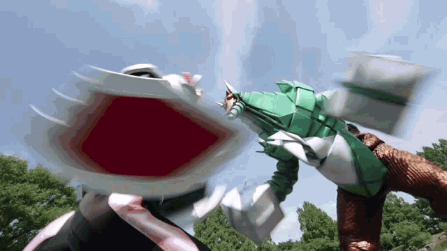 a green and white robot is fighting another robot in a park