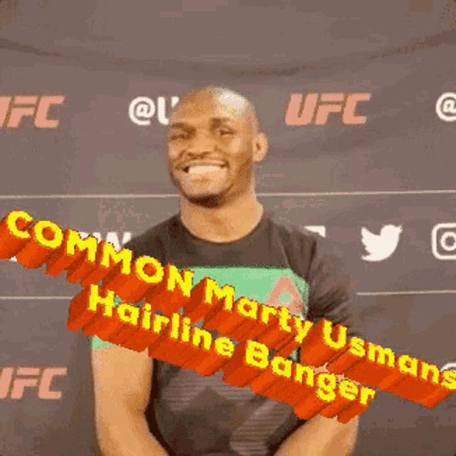 a man is smiling in front of a sign that says common marty usman