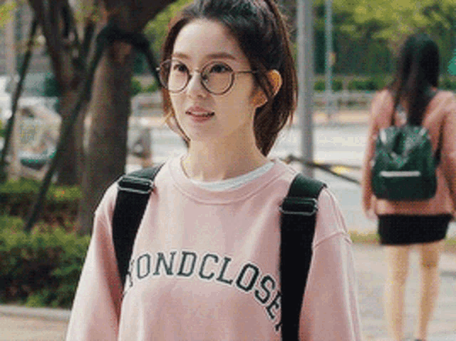 a girl wearing glasses and a pink sweatshirt that says fondclose