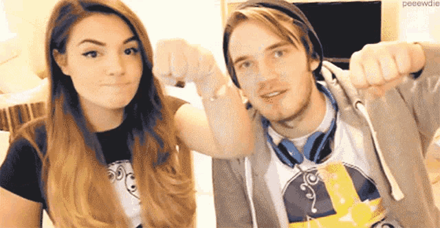 a man and a woman are posing for a picture and the man is wearing headphones and a hoodie