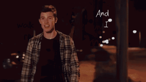 a man in a plaid shirt is standing in front of a sign that says one hundred miles on my hands