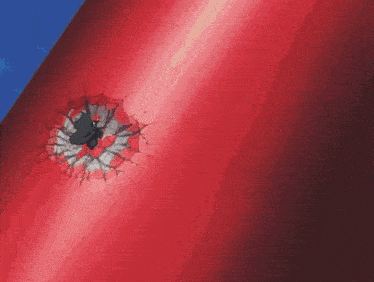 a bullet hole in a red wall with a blue background