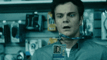 a man is wearing a staff badge around his neck