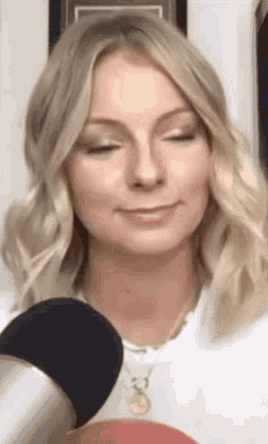 a woman with blonde hair is sitting in front of a microphone .