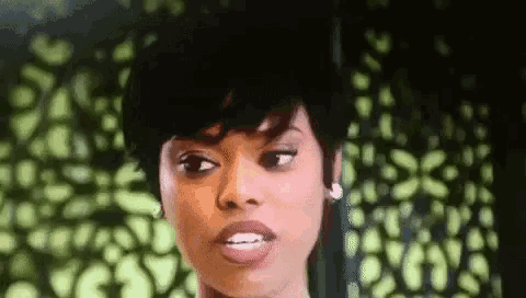 a close up of a woman 's face against a green background .