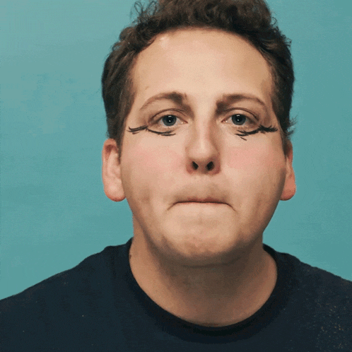 a man with fake eyelashes on his face makes a face
