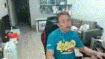 a man in a blue shirt with a banana on it is sitting in a chair .