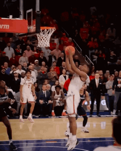 a basketball game is being played in front of a crowd and a sign that says ' rm ' on it