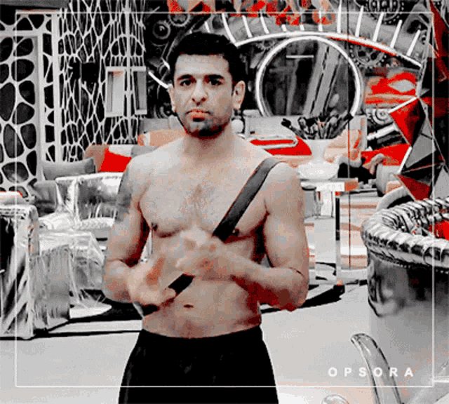 a shirtless man standing in a room with the word opsora on the bottom right