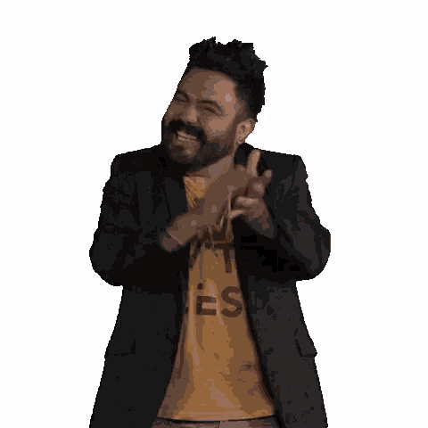 a man with a beard is wearing a yellow t-shirt that says `` live with less '' and a black jacket .