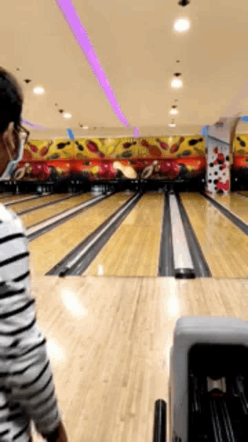 a man wearing a mask is playing bowling