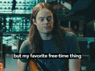 a man with long hair is holding a guitar and says but my favorite free time thing .