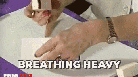 a woman is using a stamp on a piece of paper and the words breathing heavy are next to her .