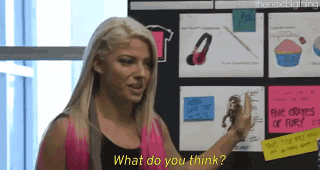 a blonde woman is standing in front of a wall with sticky notes on it and says what do you think