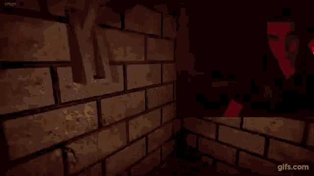 a person is standing in front of a brick wall in a dark room