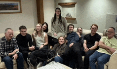 a group of people sitting on a couch with a dog in the middle