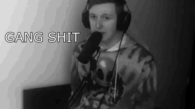 a man wearing headphones is singing into a microphone and the words gang shit are above him .