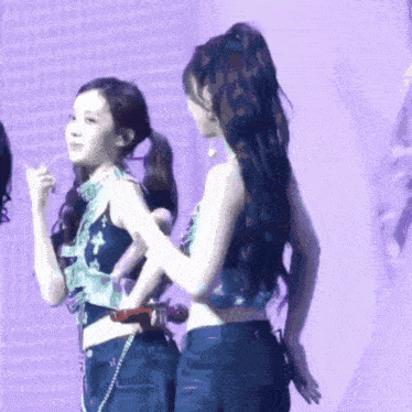 a group of girls are standing on a stage and one of them has a ponytail