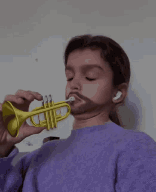 a young girl in a purple sweater is playing a yellow trumpet