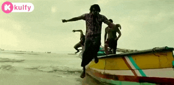 a man is jumping out of a boat into the water .