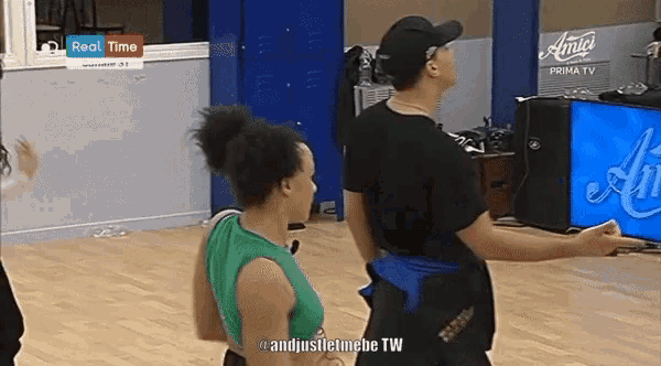a man and a woman are dancing in front of a sign that says " real time "
