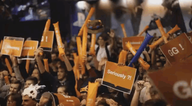 a crowd of people hold up signs that say seriously