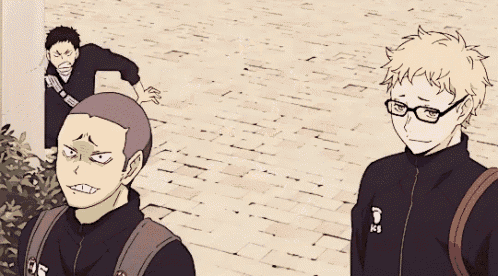 a group of anime characters are standing on a sidewalk and one of them has a letter d on his jacket