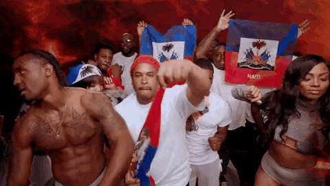 a group of people dancing with a flag that says haiti on it