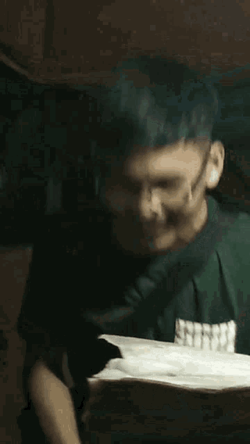 a young man wearing glasses and a green shirt smiles