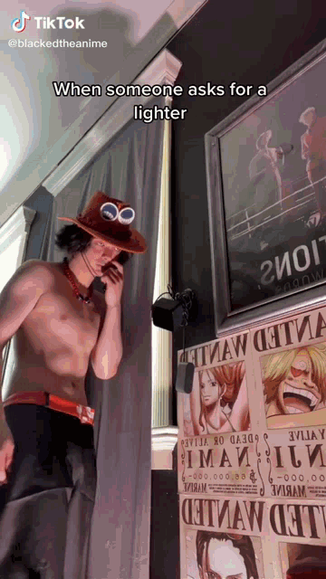 a shirtless man talking on a cell phone in front of a poster that says wanted