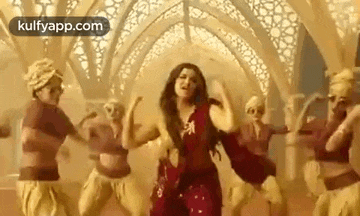 a woman is dancing in a room with a group of people .