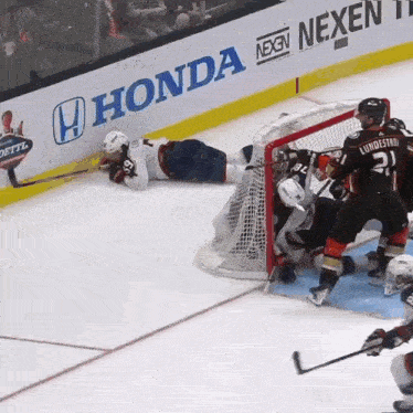 a hockey game is being played in front of a honda banner